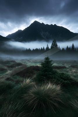 A moody panorama landscape of a mountains, fog.