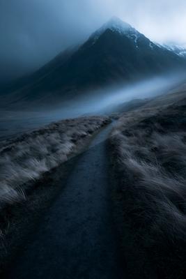 A moody landscape of mountains, valley.