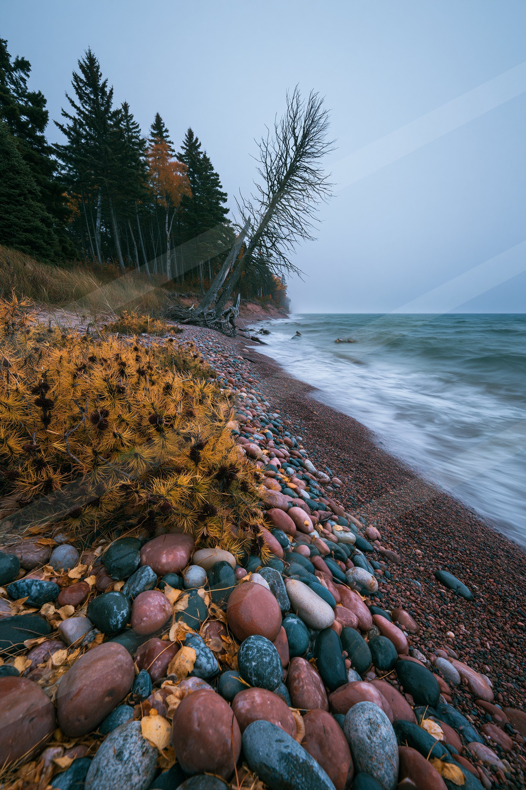 A blue hour high contrast water scene of a coastline, rocks.