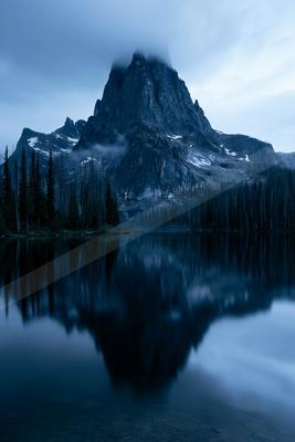 A blue hour landscape of mountains, lake.