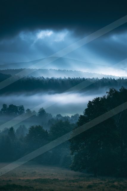 A blue hour panorama landscape of a rolling hills, fog.