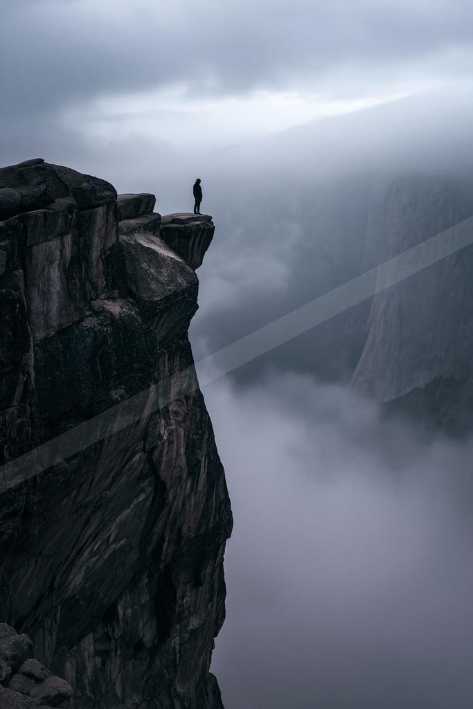 A gray-toned moody photograph of cliff, promontory, valley.