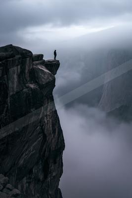 A gray-toned moody photograph of cliff, promontory, valley.