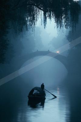 A black-toned moody photograph of gondola, paddle, canoe.