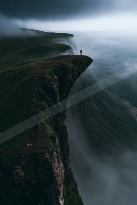 A dramatic landscape of valley, mountains, storm.