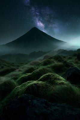 A night landscape of mountains, field, starry sky.