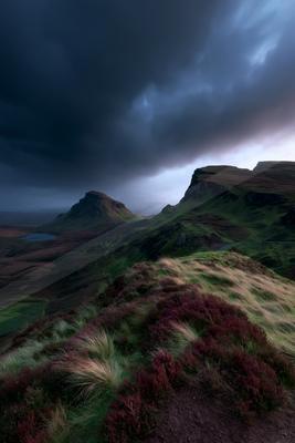 A moody landscape of mountains, valley, storm.