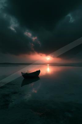 A small wooden boat floats on a glassy body of water under a dramatic sky filled with dark storm clouds, with the setting sun breaking through on the horizon an