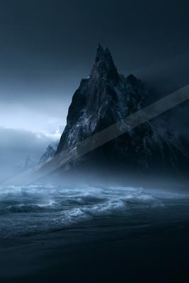 A night landscape of mountains, ocean, fog.