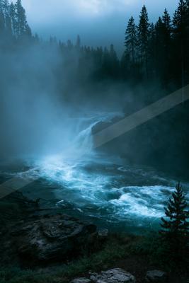 A blue hour long exposure water scene of river, waterfall, fog.