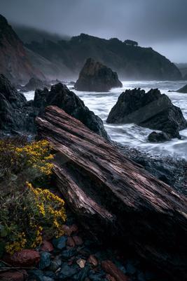 A moody water scene of beach, valley, ocean.