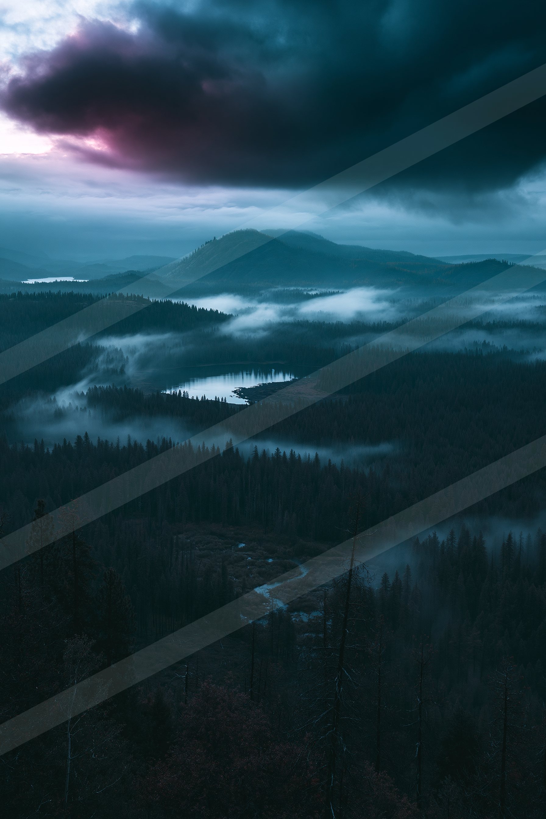 A blue hour panorama landscape of a valley, fog.
