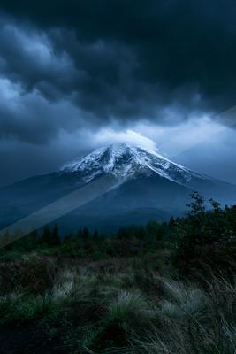 A moody landscape of mountains, storm.