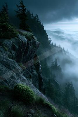 A dramatic landscape of valley, mountains, forest.