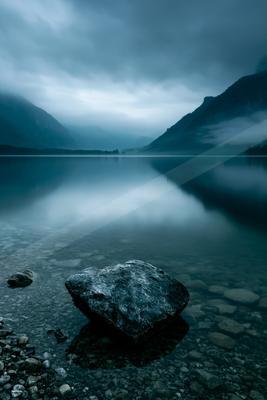 A serene water scene of lake, mountains.