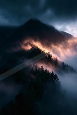 A night landscape of mountains, sunrise, fog.