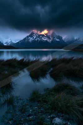A night landscape of mountains, lake, storm.