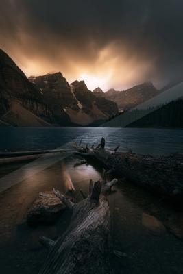A dramatic long exposure water scene of lake, mountains, storm.
