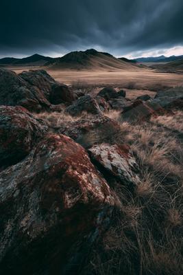 A moody landscape of desert, valley, mountains.