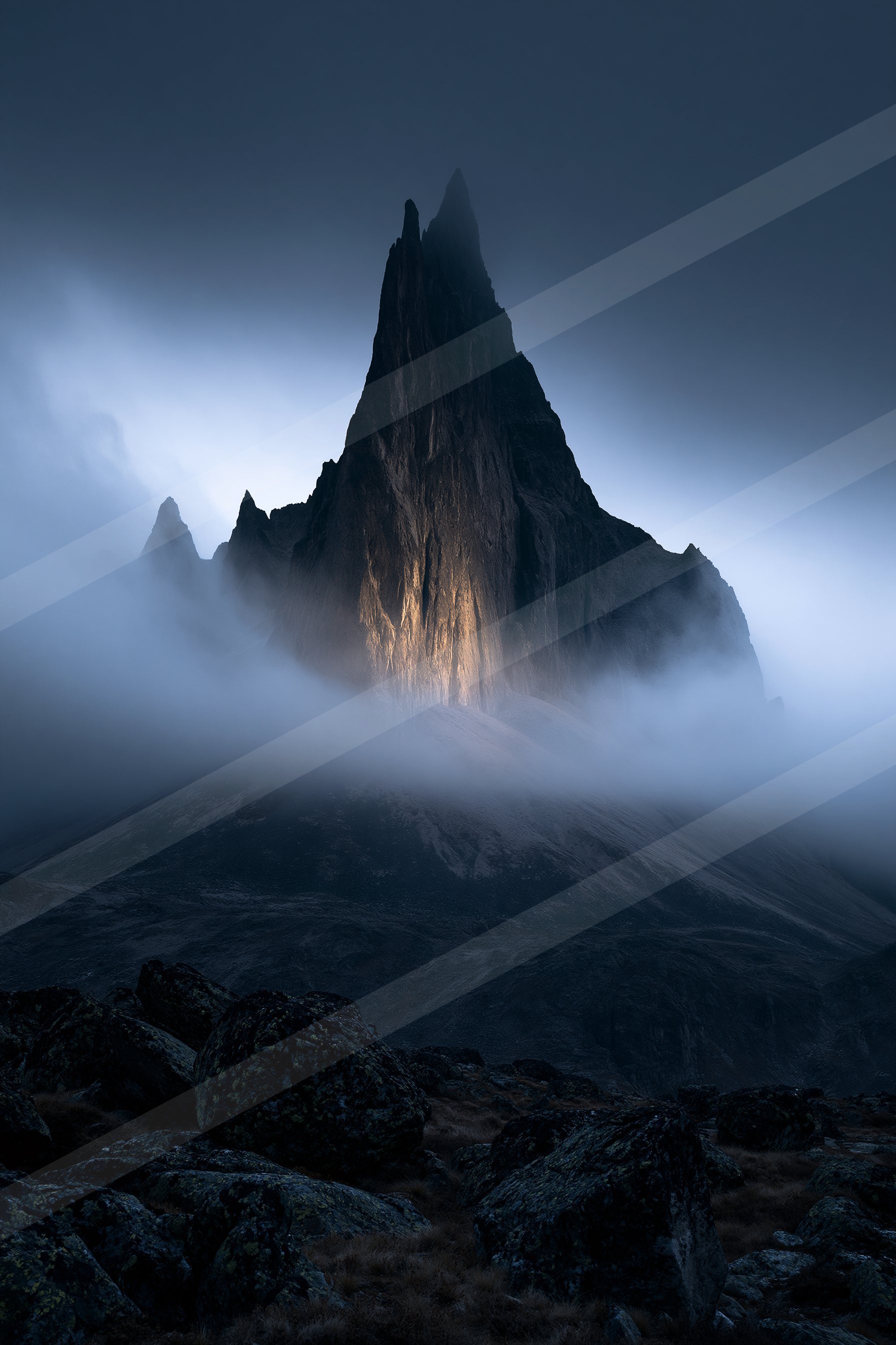 A towering mountain peak bathed in soft moonlight, surrounded by mist and rugged terrain.