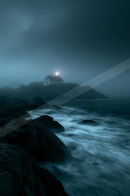 A white lighthouse with a glowing beacon stands on a rocky headland surrounded by thick fog, overlooking a turbulent sea with waves crashing against dark rocks 