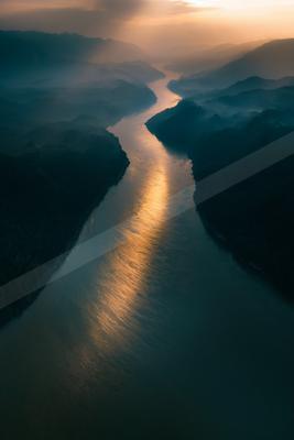 A moody water scene of river, mountains, ocean.