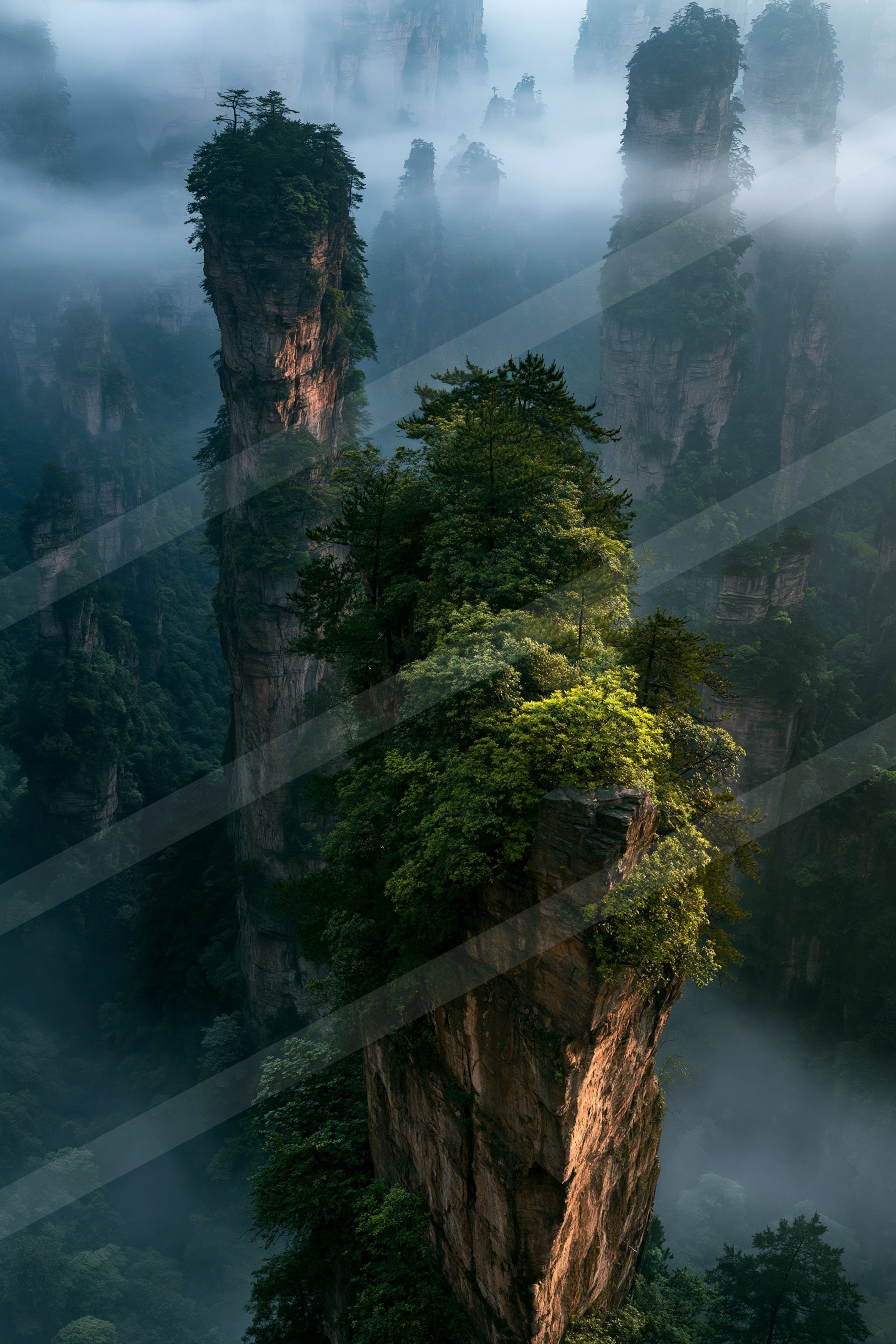 A serene landscape featuring towering rock formations shrouded in mist, covered in lush green vegetation.