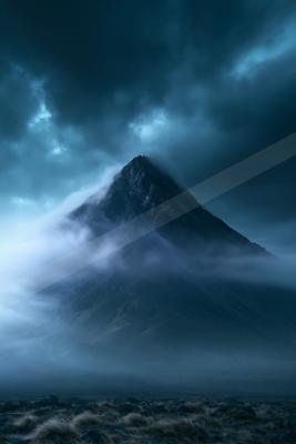 A dramatic landscape of mountains, storm, fog.