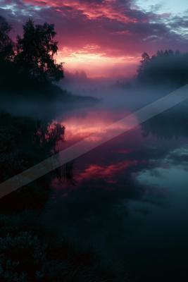 A serene lake reflects a vibrant red and pink sunset sky, surrounded by dark silhouettes of trees and thick fog hovering over the water.