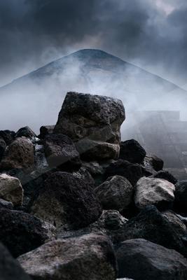 A dramatic landscape of mountains, storm, clouds.