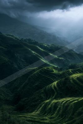 A moody landscape of field, valley, mountains.