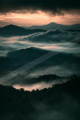 A brown-toned moody photograph of alp, valley, volcano.