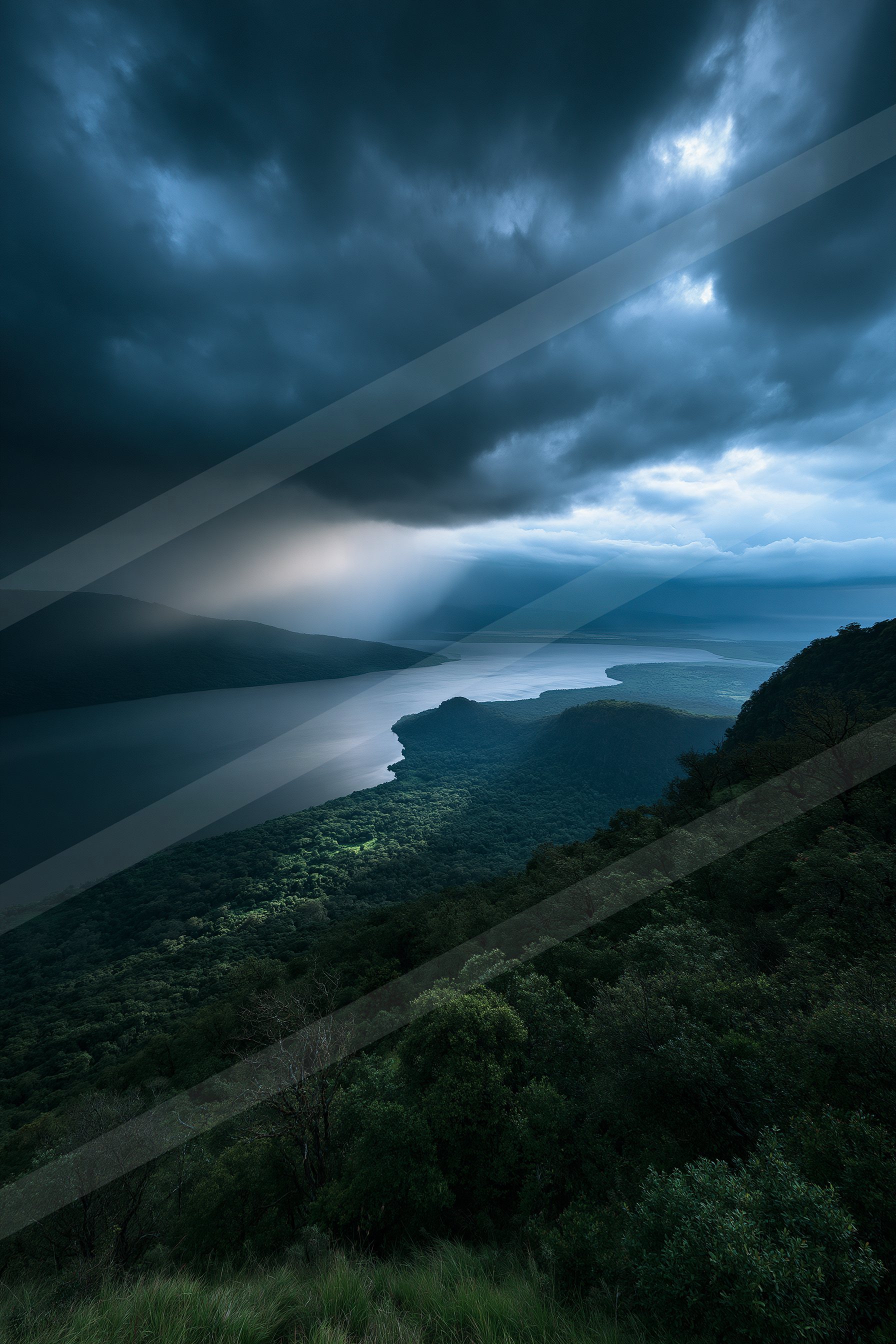 A serene lake surrounded by lush greenery under a moody sky filled with dark clouds.