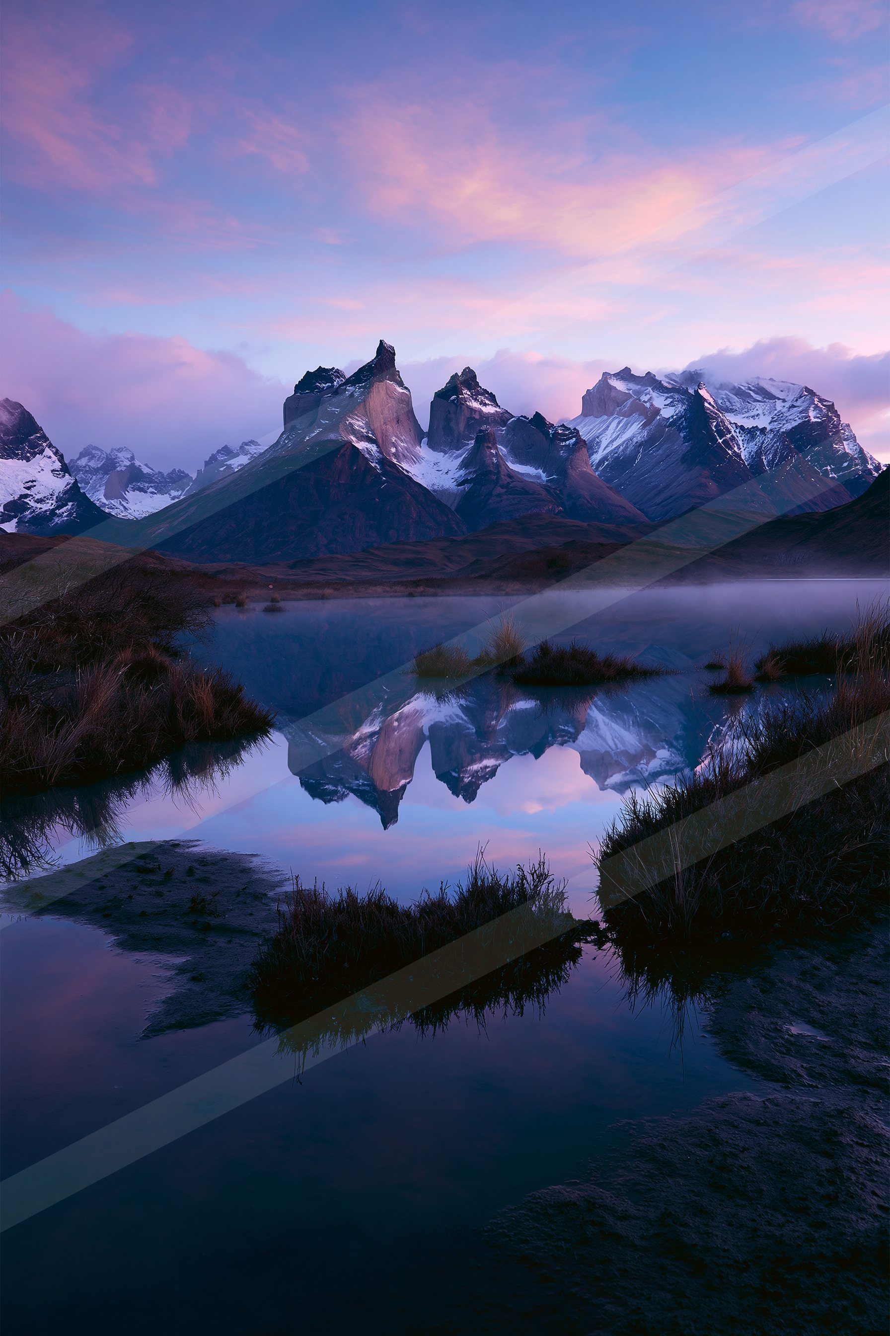 A serene twilight scene featuring snow-covered mountain peaks reflected perfectly in a calm, dark blue lake. The sky is painted with hues of purple and pink, cr
