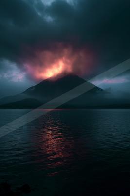 A moody landscape of mountains, lake, storm.