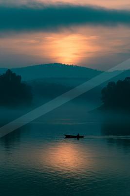 A black-toned moody photograph of lakeside, boathouse, canoe.