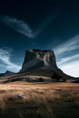 A moody landscape of mountains, valley.