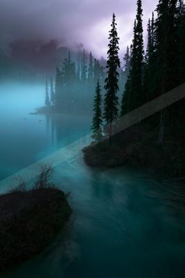 A blue hour water scene of lake, river, mountains.