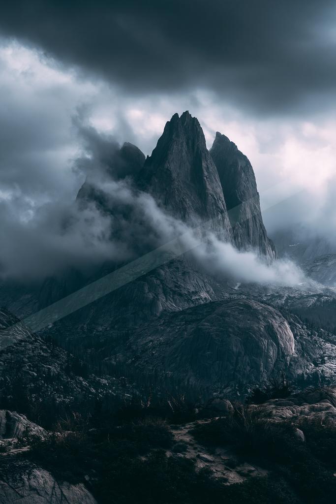 A gray-toned moody photograph of alp, valley, cliff.