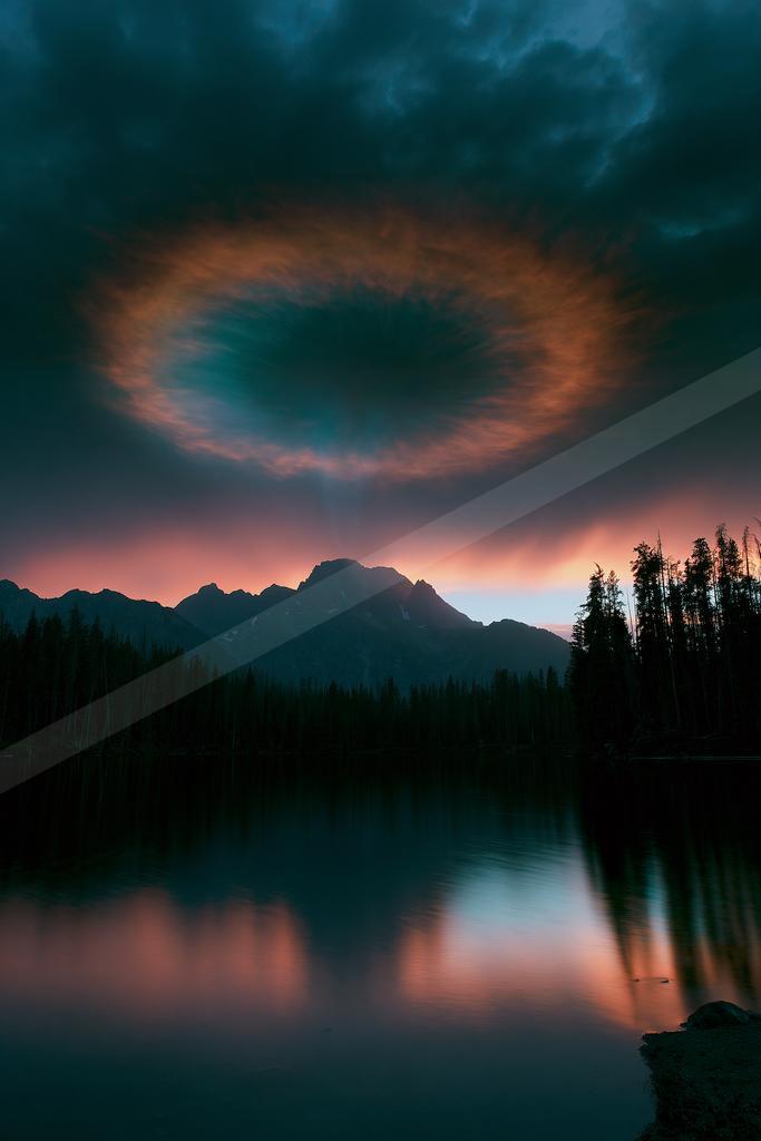 A dramatic water scene of lake, clouds, reflection.