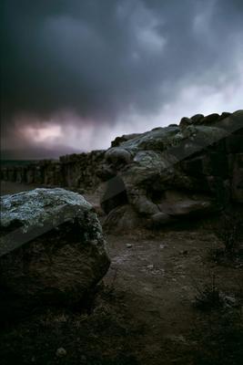 A night sky scene of storm, clouds, rocks.