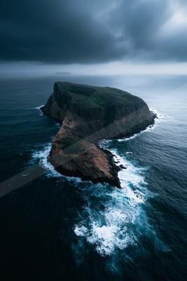 A moody water scene of ocean, waterfall.