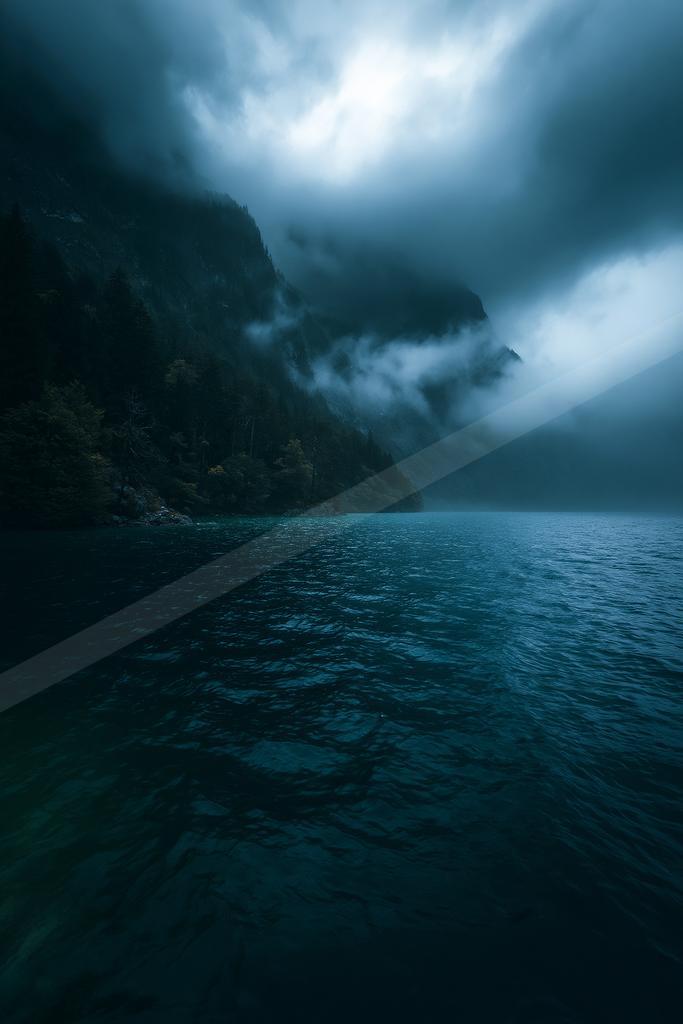 A black-toned moody photograph of cliff, promontory, seashore.