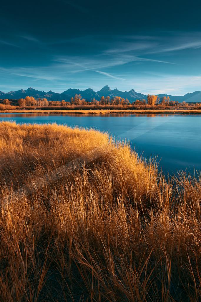 A blue hour long exposure landscape of field, lake, valley.