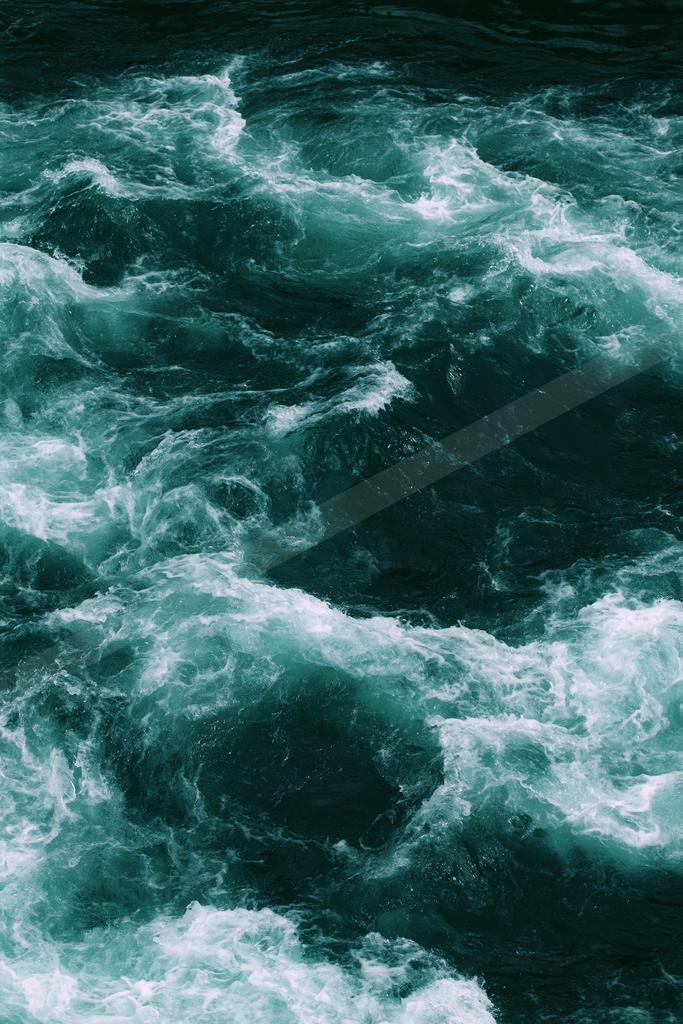 A bright water scene of ocean, waterfall.