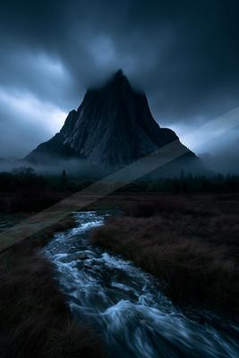 A powerful, jagged mountain peak rises through thick, dark storm clouds, with a fast-flowing stream winding through a grassy meadow in the foreground.