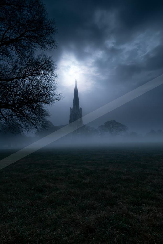 A black-toned moody photograph of church, obelisk, castle.