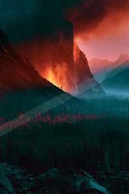A towering mountain peak bathed in fiery red light against a dark sky, with a forested foreground shrouded in misty twilight.