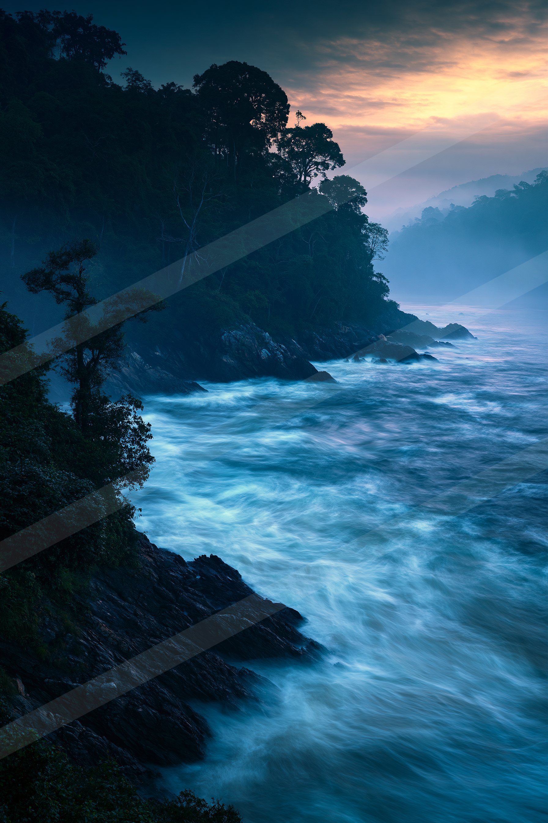 A blue hour long exposure water scene of a coastline, fog.