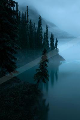 A blue hour water scene of lake, mountains.